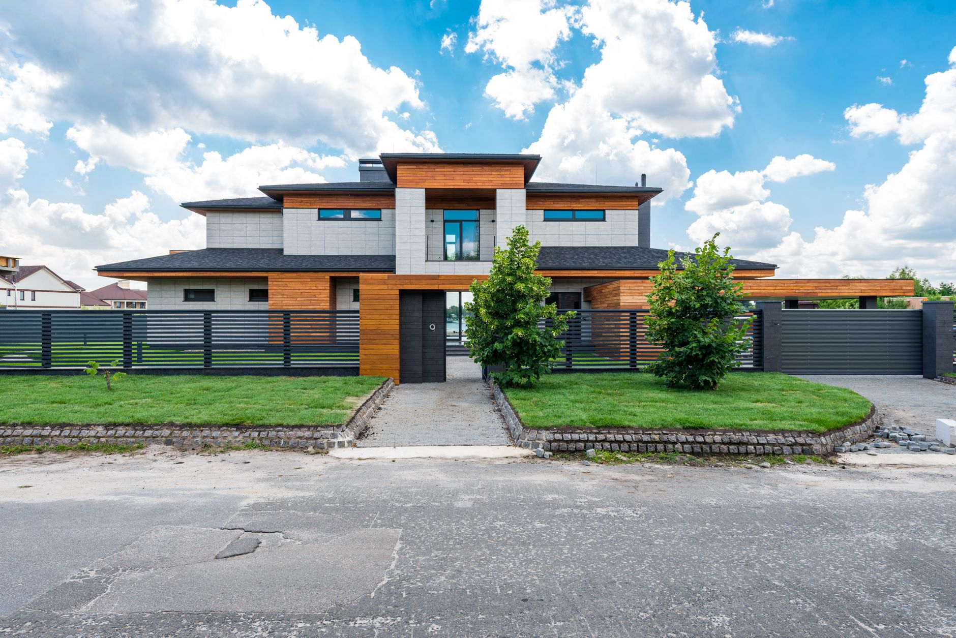Luxurious waterfront mansion with expansive garden and modern architecture, showcasing the most expensive homes for sale